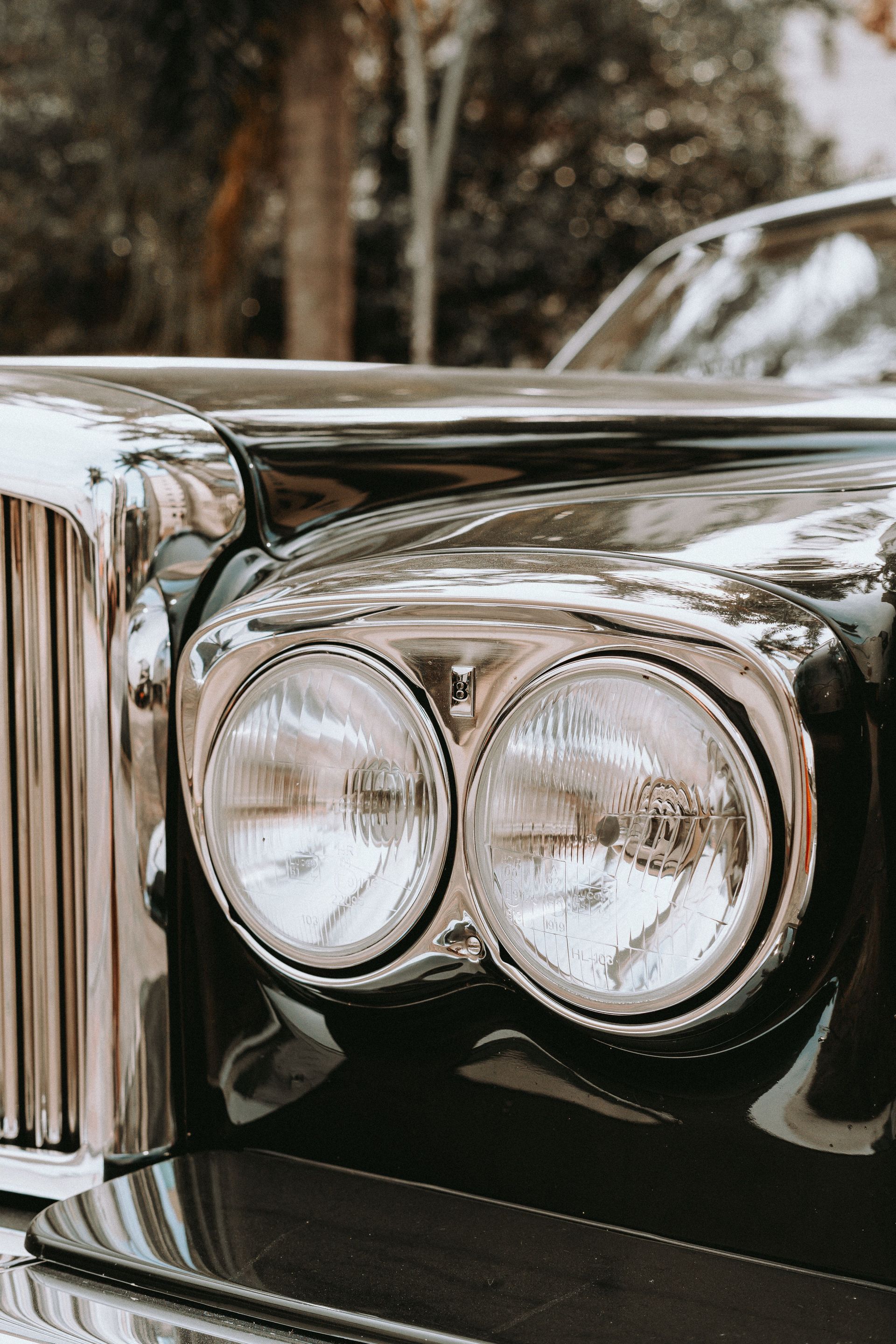 A detailed view of a classic car's headlights and chrome finish, highlighting vintage elegance.